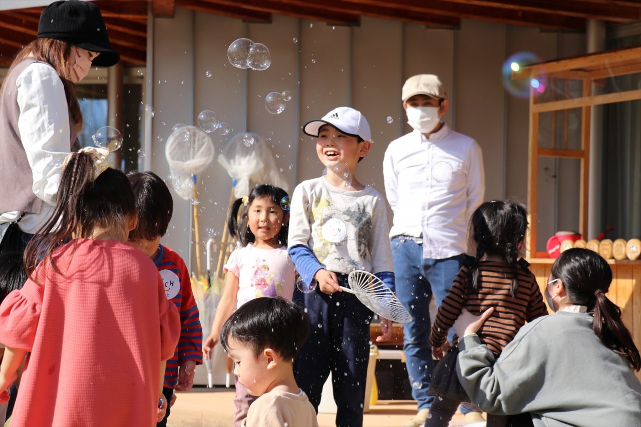 シャボン玉を囲んであそぶ子どもたち