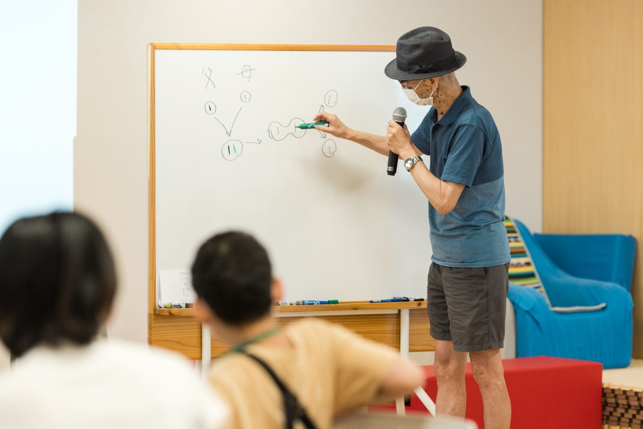男性がマイクを持って話している様子