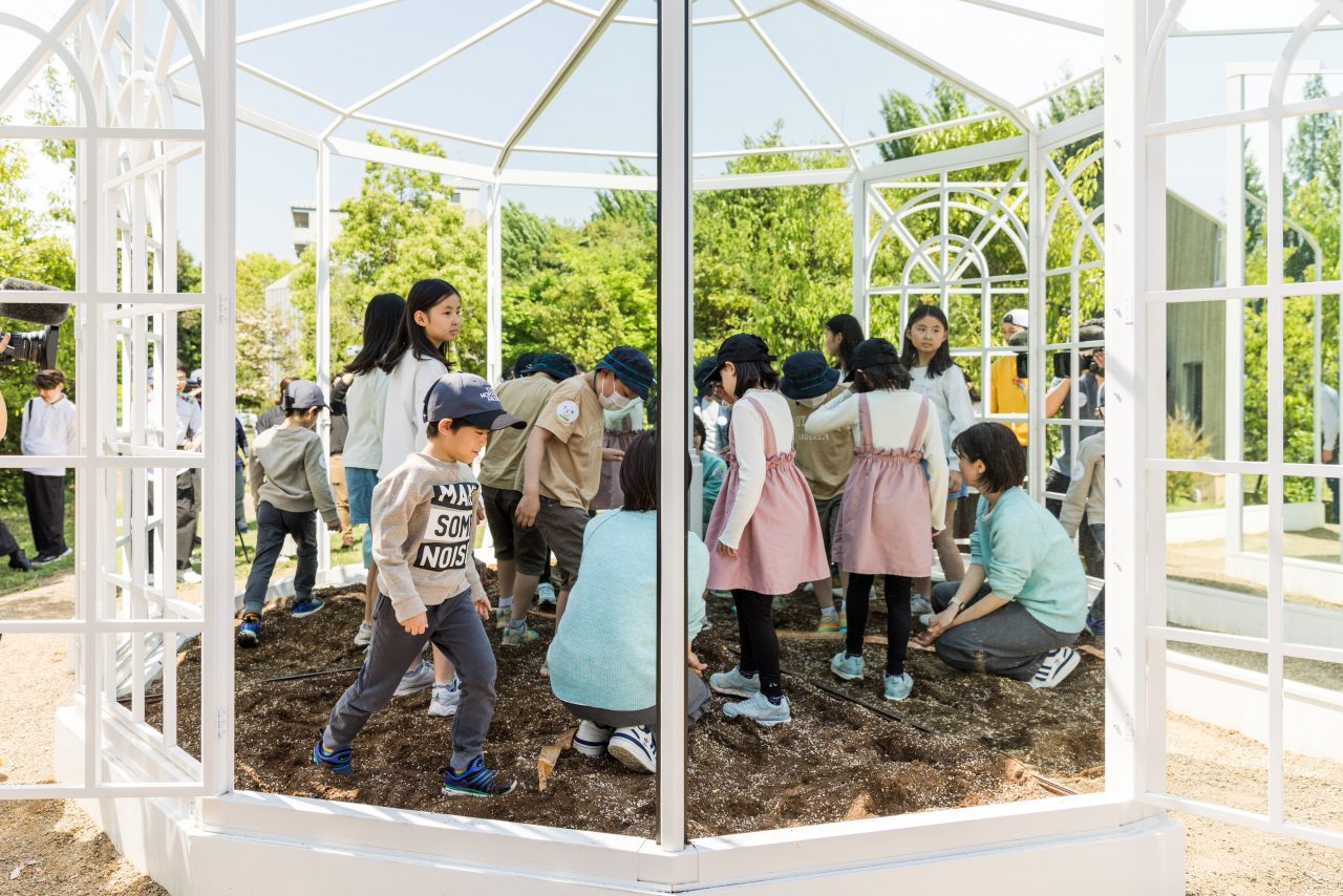 ＜画像⑦の代替テキスト＞
[写真]花壇に入った4人の子どもとスタッフのひとりが中を歩いています。鏡にはふたつの角度でうつっています